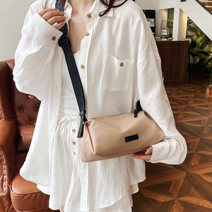 Chic beige nylon crossbody bag with adjustable wide strap and zipper closure in cozy cafe
