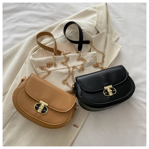 Detail view of retro saddle bags with oval metal buckles and gold chain straps