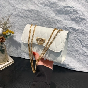 Elegant white quilted leather crossbody bag with gold buckle and chain strap detail