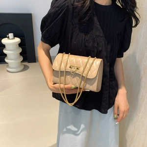 Elegant beige quilted crossbody bag with gold chain strap and metal lock closure