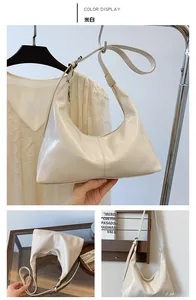 Detail view of off-white retro crescent tote bag with smooth synthetic leather and silver hardware