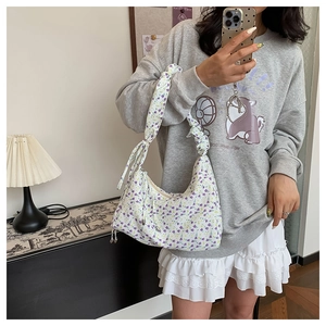 Detail of floral hobo bag featuring purple flowers and pleated cloud shoulder strap