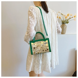 Vista dettagliata di una borsa verde con paillettes indossata da una modella