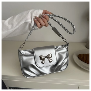 Détail d'un sac à bandoulière argenté plissé avec boucle noeud et anse tressée sur blanc