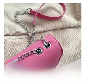 Close-up of pink crossbody bag with silver eyelet hardware and chain strap details