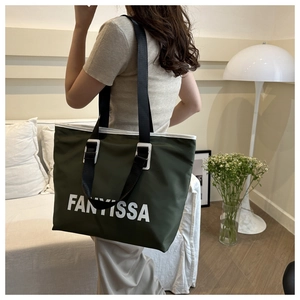 Close-up of deep green waterproof tote bag with FANTISSA logo and white trim detail