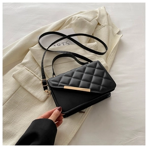 Détail d'un sac bandoulière noir matelassé avec finitions dorées et sangle ajustable