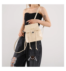 Model wearing a cream PU leather convertible backpack showing gloss texture and gold logo