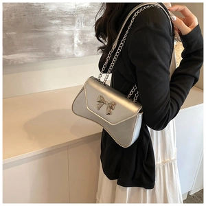 Detail of silver metallic crossbody bag with 3D bow buckle and chain strap