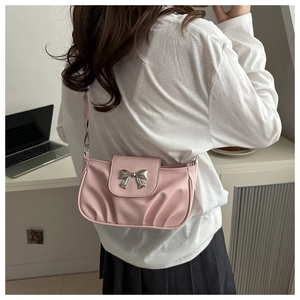 Détail du sac rose montrant le nœud argenté et la texture plissée en similicuir souple
