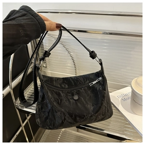 Détail du sac à bandoulière noir à texture plissée avec fermeture éclair argentée