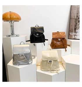 Detailed view of four colorful mini PU leather backpacks with drawstring and metal locks