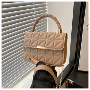 Close-up of quilted beige crossbody bag with woven handle and metal chain strap