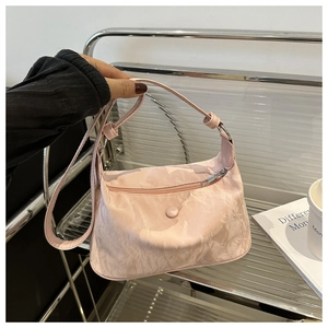 Gros plan du sac à main rose montrant la texture de pierre et le zip en métal argenté