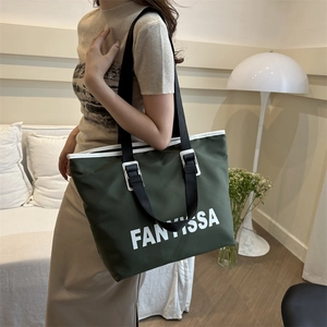 Olive green waterproof nylon tote bag with large white logo and wide black straps