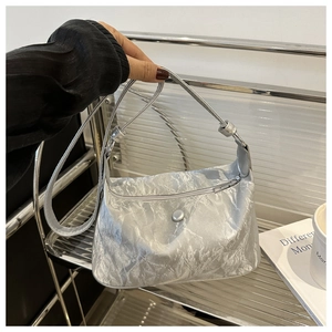 Détail du sac argenté métallisé en demi-lune avec texture plissée et fermeture à pression