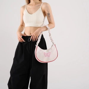 Sac hobo crème chic avec broderie papillon rose et bordure rouge avec bandoulière froissée
