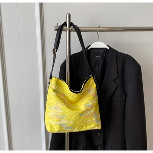 Détail du sac à bandoulière jaune avec broderie et motifs texturés élégants