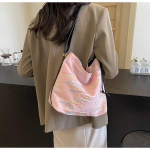 Détail du sac cabas en tissu rose avec broderie colorée et bandoulière en cuir noir