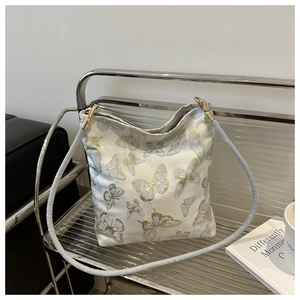 Detailed view of bamboo butterfly golden embroidery on a premium white shoulder bag