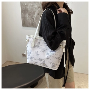 Détail latéral du sac à bandoulière imprimé papillon porté par un mannequin réel