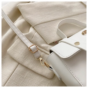 Detailed macro view of white PU leather texture with elegant gold metal hardware and buckle