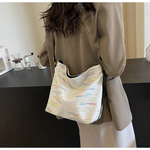 Détail du sac hobo blanc matelassé avec broderie colorée et bandoulière en cuir noir