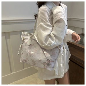 Sac à bandoulière avec imprimé papillon et cordons latéraux porté par un mannequin