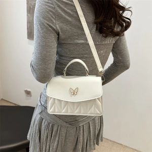 Elegant white square handbag with golden butterfly clasp and quilted texture for women