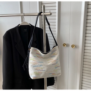 Détail d'un sac cabas blanc avec logo embossé et broderie colorée sur le cuir de qualité