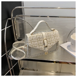 Detail of tweed and white leather handbag with gold buckle on a modern stand