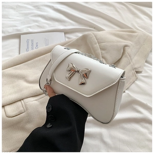 Detailed view of silver bow clasp and textured white PU leather on small square bag