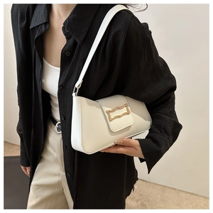 Detail of white baguette shoulder bag with gold metal buckle on a female model