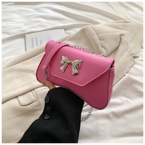 Detail of pink leather handbag with silver metal bow and stylish chain shoulder strap