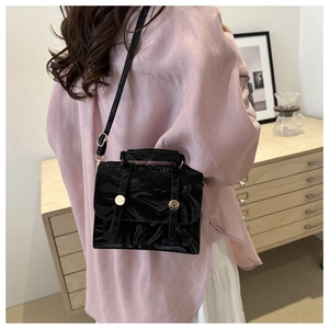 Close-up of vintage black marble pattern handbag with a round gold magnetic buckle
