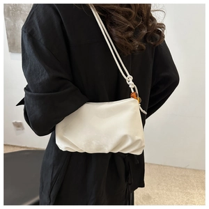 Détail du sac nuage blanc plissé avec perles colorées sur la bandoulière