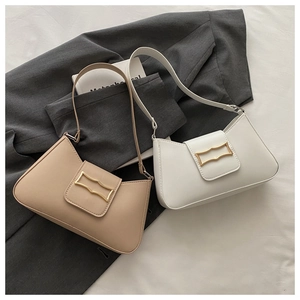 Detail of minimalist underarm bags in beige and white leather with gold buckle accents