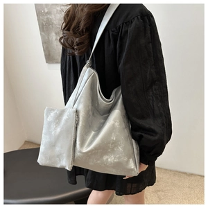 Detail of silver metallic tote bag set with wrinkled leather texture and matching pouch