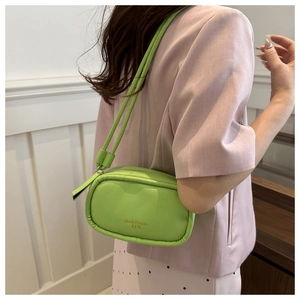 Detail of lime green PU leather crossbody bag with Do&thinks DX logo and zipper