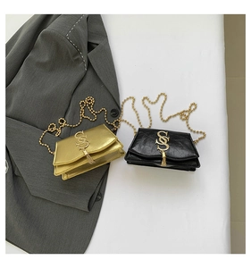 Detail of vintage flap crossbody bags in gold and black with tassel and chain straps