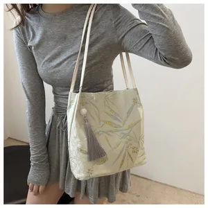 Dettaglio della borsa tote cinese con ricamo di foglie di bambù ed elegante nappa grigia