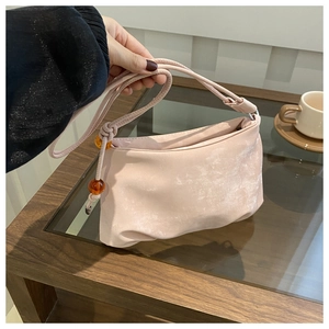 Vue détaillée du sac hobo rose en satin avec perles d'ambre sur la bandoulière
