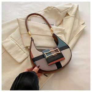 Detail of hobo bag with geometric color-block pattern and gold metal buckle on a blazer