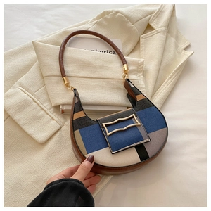 Detail of color-block crescent shoulder bag with vintage gold buckle on blazer
