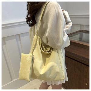 Detailed view of yellow faux suede tote bag and matching inner pouch on model