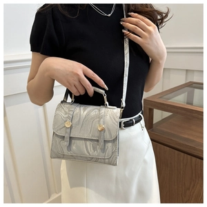 Detail of grey marble pattern faux leather crossbody bag with gold hardware accents