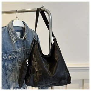 Close-up of black tote bag with matching coin purse and distressed leather texture