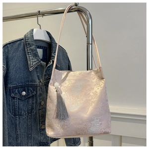 Dettaglio borsa a spalla in seta jacquard rosa con ricami e nappa argento