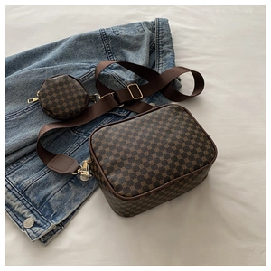 Flat lay of vintage brown plaid crossbody bag with small coin purse and canvas strap