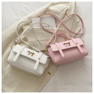 Detail showing white and pink mini bags with golden metal bow buckles and top handles